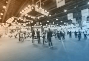 Trade show exhibition hall with attendees and booths
