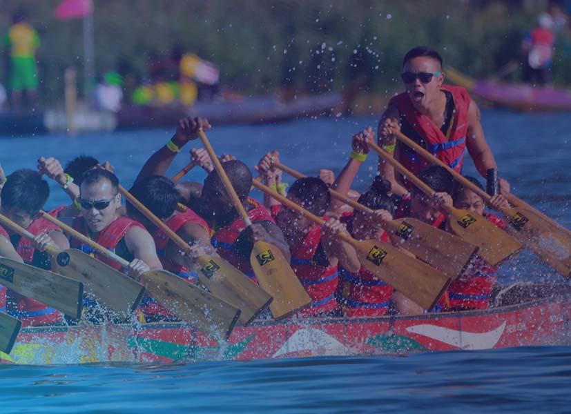 Image of a group of dragon boat rowers in action during a dragon boat race event.
