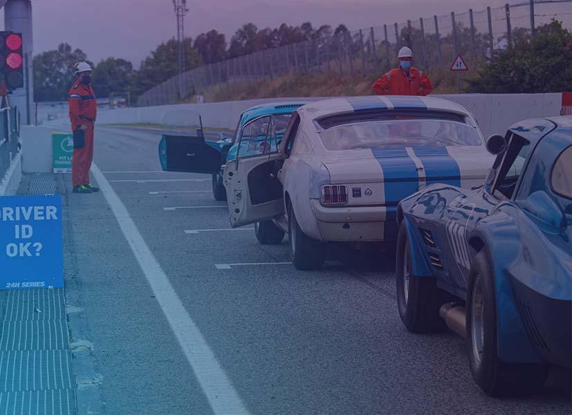 Image of a motorsport race starting grid with race cars lined up at the starting line.