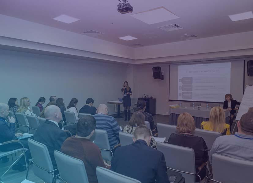 Image of participants seating in a room watching a speaker present during a workshop event.