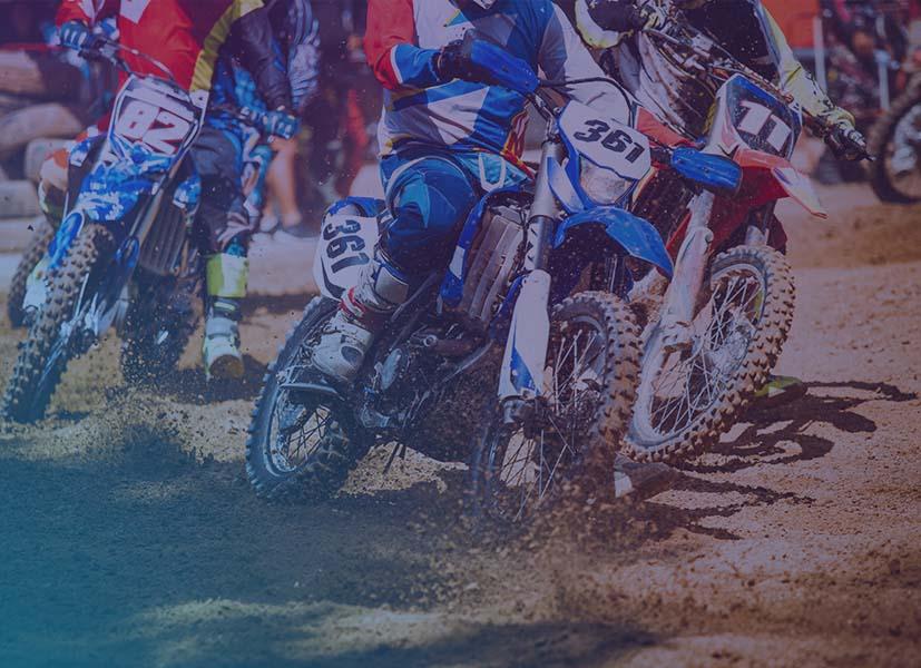 Close-up image of competitors on dirt bikes during a dirt bike race.