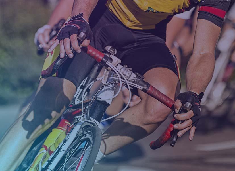 Close-up image of a cyclist leaning into a corner during a cycling summer camp event training activity.