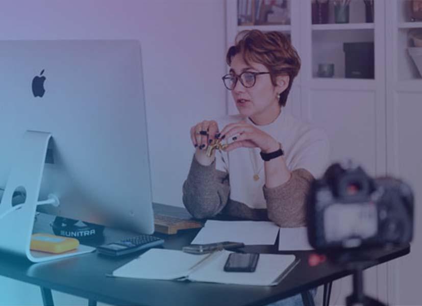 Image of a women at a desk in front of a computer participating in an online seminar event.