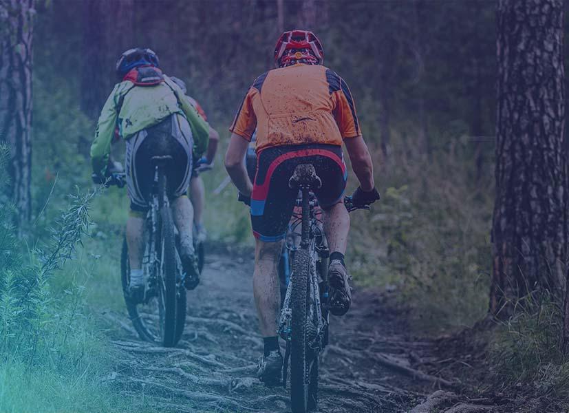 Image of 2 mountain bike race participant going down a course during a mountain biking event.